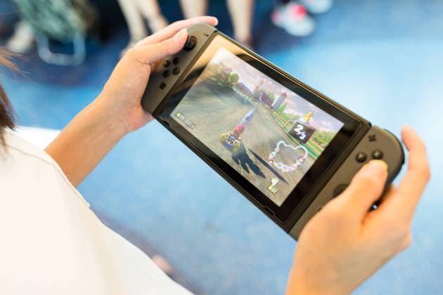 Hong Kong, 19 May 2017 -: Hand holding Nintendo Switch , 25152892.jpg, hong kong, woman, holding, nintendo, switch, video, device, new, console, leisure, play, gaming, controller, red, gamer, display, technology, excited, thrilled, monitor, tech, screen, electronic, toy, entertainment, blue, hand, mario kart, 8, mobile, portable, train, compartment, inside, transportation, transport, female, lady, racing, game, fun, funny, cheerful,