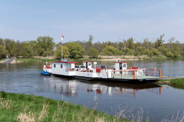 Aken Saxony Anhalt Germany April 2022 Gierseilfähre Barby motorless reaction ferry crossing the River Elbe. A reaction ferry uses the motion of the current of the water going back and forth like a pendulum attached by wires to an anchor point further upstream. Barby Sachsen Anhalt Deutschland April 2022 Gierseilfähre Barby über die Elbe. Eine Gierseilfähre nutzt die Bewegung des hin- und hergehenden Wasserstroms wie ein Pendel, das mit Drähten an einem weiter stromaufwärts gelegenen Ankerpunkt befestigt ist.