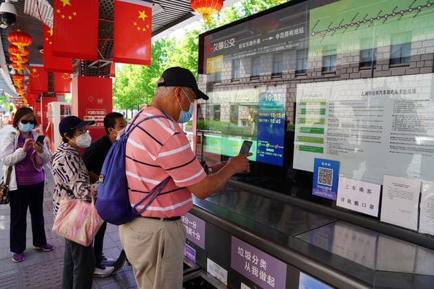 (220522) -- SHANGHAI, May 22, 2022 -- A man scans the QR code at a bus stop in Shanghai, east China, May 22, 2022. Shanghai started to resume cross-district public transport starting from Sunday. Transport service on four subway lines and 273 bus routes has resumed on Sunday covering the central urban areas and the city s airports, railway stations, and hospitals. Passengers are allowed to use the public transport system only when they have negative result certificates for nucleic acid testing taken within 48 hours. ) CHINA-SHANGHAI-PUBLIC TRANSPORTATION-RESUMPTION (CN) WangxChenyang 
