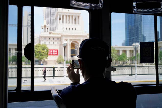 (220522) -- SHANGHAI, May 22, 2022 -- A passenger takes photos through the window on a bus in Shanghai, east China, May 22, 2022. Shanghai started to resume cross-district public transport starting from Sunday. Transport service on four subway lines and 273 bus routes has resumed on Sunday covering the central urban areas and the city s airports, railway stations, and hospitals. Passengers are allowed to use the public transport system only when they have negative result certificates for nucleic acid testing taken within 48 hours. ) CHINA-SHANGHAI-PUBLIC TRANSPORTATION-RESUMPTION (CN) WangxChenyang 