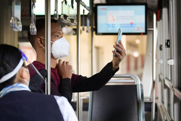 (220522) -- SHANGHAI, May 22, 2022 -- A passenger scans the QR code on a bus in Shanghai, east China, May 22, 2022. Shanghai started to resume cross-district public transport starting from Sunday. Transport service on four subway lines and 273 bus routes has resumed on Sunday covering the central urban areas and the city s airports, railway stations, and hospitals. Passengers are allowed to use the public transport system only when they have negative result certificates for nucleic acid testing taken within 48 hours. ) CHINA-SHANGHAI-PUBLIC TRANSPORTATION-RESUMPTION (CN) LixHe 