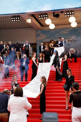 Mitglieder der feministischen Bewegung Les Colleuses halten ein Transparent mit den Namen von 129 Frauen, die seit den letzten Filmfestspielen in Cannes an häuslicher Gewalt gestorben sind, bei der Premiere des Kinofilms Holy Spider Les nuits de Mashhad auf dem Festival de Cannes 2022 75. Internationale Filmfestspiele von Cannes im Palais des Festivals. Cannes, 22.05.2022