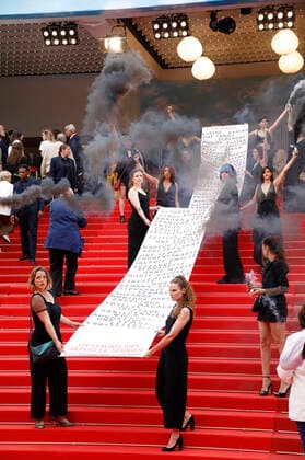 Mitglieder der feministischen Bewegung Les Colleuses halten ein Transparent mit den Namen von 129 Frauen, die seit den letzten Filmfestspielen in Cannes an häuslicher Gewalt gestorben sind, bei der Premiere des Kinofilms Holy Spider Les nuits de Mashhad auf dem Festival de Cannes 2022 75. Internationale Filmfestspiele von Cannes im Palais des Festivals. Cannes, 22.05.2022