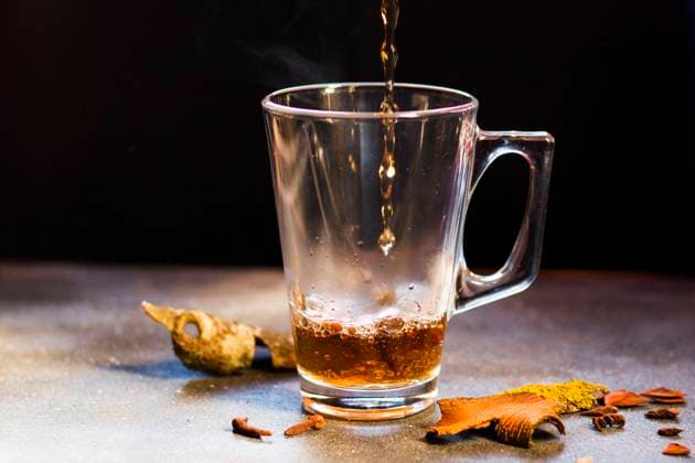 Hot grog on the table, rum and tea with cinnamon and clove, on the black background. , 34322276.jpg, grog, tea, rum, cinnamon, clove, juice, food, seasoning, seasonal, fruit, spice, winter, hot, holiday, punch, holidays, cocktail, beverage, hot tea, ingredients, cup, christmas background, wine, mug, aroma, spices, autumn, vintage, healthy, background, warm, traditional, orange, drink, christmas, brown, aromatic, dry, festive, homemade, anise, oranges, glass, alcohol, xmas, table, decoration, tradition, stick, black background