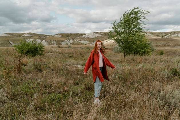 IMAGO Creative: Ruhe im Chaos Young woman spinning in grass field model released, Symbolfoto property released, OGF01217