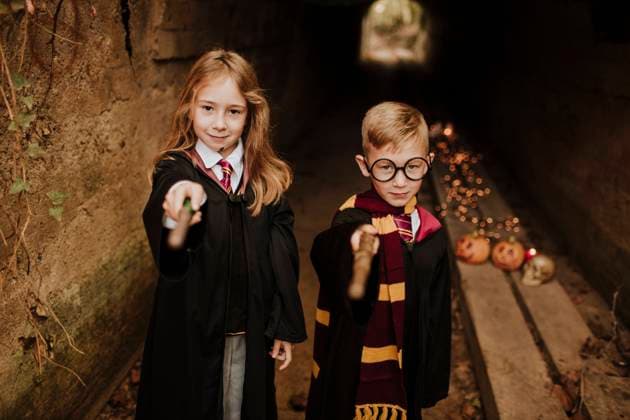 Boy and girl in witch and wizard costumes pointing magic wands model released, Symbolfoto, GMLF01296