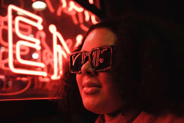 Creative Highlights Symbolbilder Young woman wearing sunglasses by illuminated wall at night model released, Symbolfoto, ASGF02288