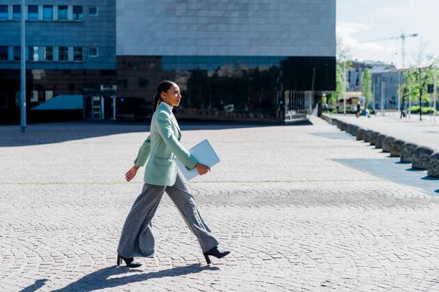Creative Highlights Symbolbilder Confident businesswoman with laptop walking by office building model released, Symbolfoto, MEUF05224