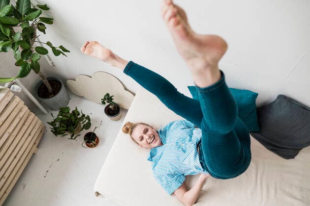 Creative Highlights Symbolbilder Playful businesswoman practicing yoga on bed at home model released, Symbolfoto property released, JOSEF09071