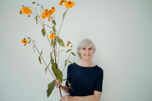 Creative Highlights Symbolbilder Smiling senior woman with twig standing against white background model released, Symbolfoto property released, JOSEF09342