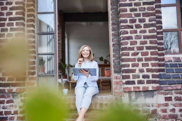 IMAGO Creative: Business, Innovative Technologie-Lösungen Smiling businesswoman with tablet PC sitting on doorway model released, Symbolfoto property released, FMKF07605
