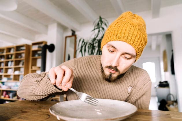 Hungry man scratching last rice corn from his plate model released, Symbolfoto property released, KMKF01834