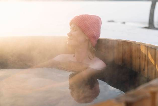 IMAGO Creative, Jahreszeit Winter, Wellness im Spa Topless woman in knit hat taking hot water bath in winter model released, Symbolfoto property released, VPIF05959
