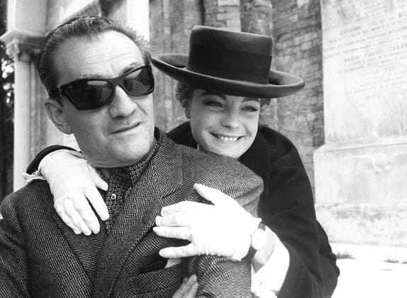 ARCHIVFOTO: Vor 40 Jahren, am 29. Mai 1982, starb die Schauspielerin Romy SCHNEIDER, Romy Schneider umarmt von hinten den Regisseur Luchino VISCONTI(mit grosser Sonnenbrille), in dessem Film Ludwig II. sie die Kaiserin Elisabeth von Oesterreich spielte, BB, sie schwarzgewandet und mit schwarzem Hut, Qf. Schwarzweissbild; 19.05.2002 *** ARCHIVE PHOTO 40 years ago, on 29 May 1982, the actress Romy SCHNEIDER died, Romy Schneider embraces from behind the director Luchino VISCONTI with big sunglasses, in whose film Ludwig II she played the empress Elisabeth of Austria, BB, she dressed in black and with black hat, Qf black and white picture 19 05 2002