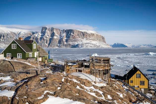 Ramshackle buildings cling to the edge of the rocks at Uummannaq in north west Greenland. Copyright: xLoopxImages RJBPhotographicx RJB03222WT009