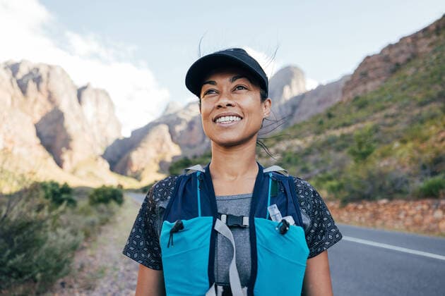 Creative Highlights Symbolbilder Portrait of a beautiful female hiker in cap. Woman in hiking attire staning in valley. Copyright: xArtemxVarnitsinxArtemxVarnitsinx