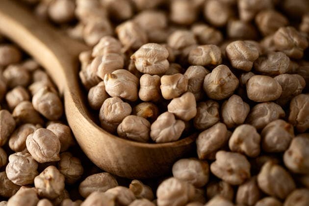 IMAGO Nature: Unsere Erde, Klimawandel, Ern?hrung, Pflanzen der Zukunft, Kichererbse Top view of wooden spoon among pile of raw chickpeas Copyright: xAlexxSalcedox Model Released