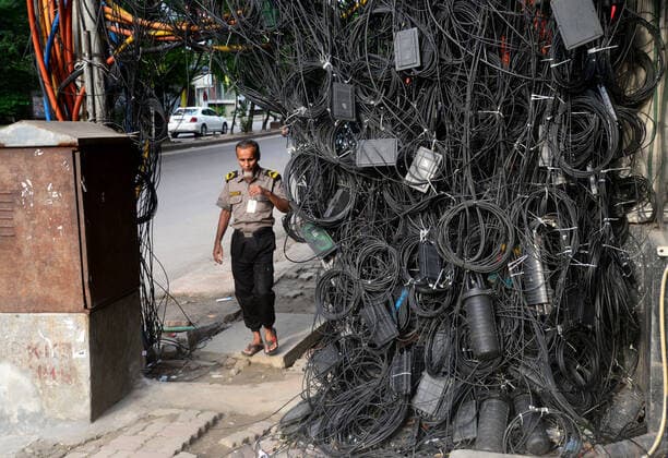 Bilder des Jahres 2022, News 06 Juni News Themen der Woche KW23 News Bilder des Tages Daily Life In Dhaka People walk through the scattered internet and satellite connection cables hanging on footpath in Dhaka, Bangladesh, on June 10, 2022. Dhaka Bangladesh  Copyright: xSTRx originalFilename: rashid-notitle220610_np7Am.jpg