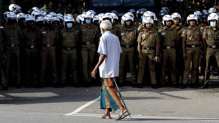 Bilder des Jahres 2022, News 06 Juni News Themen der Woche KW23 News Bilder des Tages Economic Crisis In Sri Lanka A Sri Lankan man walks watched by police officers in front of Ministry of Education during a protest at Colombo, Sri Lanka. 10 June 2022. Colombo Sri Lanka  Copyright: xTharakaxBasnayakax originalFilename: basnayaka-notitle220610_npBHQ.jpg