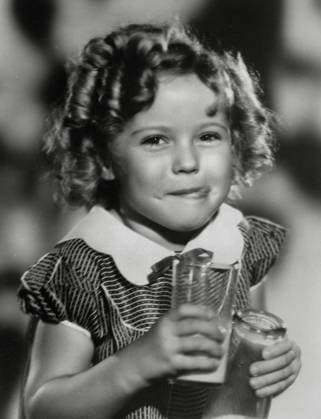 Shirley Temple, enjoying a glass of milk, circa 1934. File Reference 34145-941  Copyright: xCinemaxLegacyxCollection ThexHollywoodxArchivex 34145-941 The Hollywood Archive