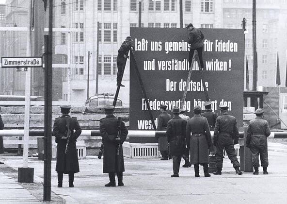 12 8 1961 - Friedrichstrasse. Understanding is Lowercase in the Soviet Zone Regime. at The Vopos Border Crossing It Triggered A Debate, and After Some Time A Vopos Climbed Up The Ladder and Made With White Paint From The Small V Is A Big V 1062_05_M_-12875-