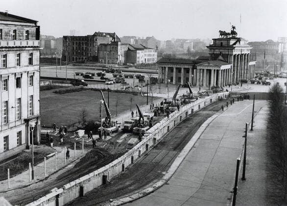 Berlin wall reinforced. Under the watchful eye of Communist police, East german workers near the Brandenburg Gate reinforce the wall dividing the city. Since erecting the wall on August 13, 1961, to stop the flow of East Germans into West Berlin, the East German Communists have added bunkers, spotlights and firing and observation posts. 1062_05_M_-12888-