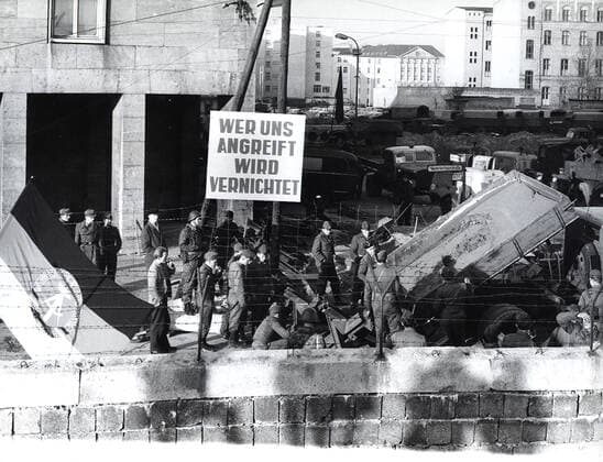 Banner Says Whoever Attacks Us Will Be Destroyed . Example of an East German Confrontational Propaganda Banner Produced By the Volksarmee and Volkspolizei 1062_05_M_-13383-