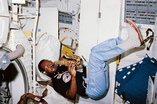 S84-27211 (8 Feb 1984) --- Astronaut Ronald E. McNair, 41-B mission specialist, uses some of his off-duty time, aboard the Space Shuttle Challenger, to play his saxaphone. 1062_36_M_-11539-