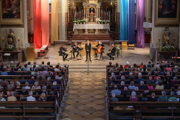 Konzert des Spring String Quartetts mit dem Countertenor Alois Mühlbacher, in der Stadtpfarrkirche St. Nikolaus, in Bad Ischl, im Rahmen der Salzkammergut Festwochen Gmunden , am 11.06.22. Das Bild zeigt den Innenraum der Stadtpfarrkirche mit Publikum und auf der Bühne dem String Spring Quarett mit dem Countertenor Alois Mühlbacher. v.l.n.r.: Violinist Christian Wirth, Violinist Marcus Wall, Countertenor Alois Mühlbacher, Violoncellist Stephan Punderlitschek, Violaspieler Julian Gillesberger 2022 - Konzert des Spring String Quartetts mit dem Countertenor Alois Mühlbacher, in der Stadtpfarrkirche St. Nikolaus, in Bad Ischl, im Rahmen der Salzkammergut Festwochen Gmunden , am 11.06.22