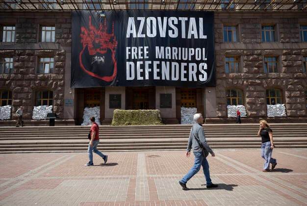 News Bilder des Tages several people walk in front of the City Hall where a poster hangs that demands the freedom of Ukrainian soldiers held by Russian forces, today, in Kyiv, Ukraine, 14 June 2022. Bucha is reborn among the destruction caused by the Russian invasion !ACHTUNG: NUR REDAKTIONELLE NUTZUNG!  Copyright: xOrlandoxBarríax AME6606 20220614-a39c24966c4031109fbd8647391b627ef055277c