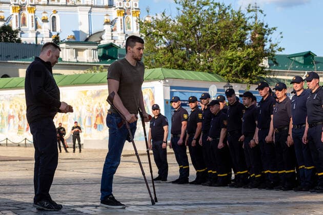 News Bilder des Tages June 14, 2022, Kiev, Ukraine: A service man who lost his leg in Russian artillery attack departs after being decorated with the Medal of the Defender of the Fatherland at Michailovskyi Square in front of Saint Michail Monastery in an Old Town of Kiev. The Ministry of Internal Affairs awarded medals to Rescuers, police and border guards who have shown a special feat in countering Russian aggression in the war against Ukraine, some of whom were wounded in the line of duty. Kiev Ukraine - ZUMAs197 20220614_zaa_s197_258 Copyright: xDominikaxZarzyckax