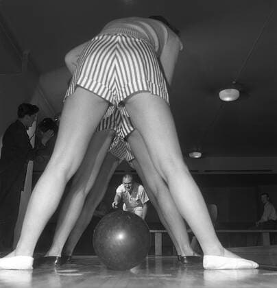 Bowling in the 1950s. A man with three young women in a bowling alley. They are dressed in short striped skirts and jumpers. The three girls are all theatre actresses; Ingrid Björk, UllaCarin Rydén and Brita Ulfberg. Ewert Ekström shows is instructing them in bowling. He was a professional bowler player in the 1930s and is at this time an instructor and owner of the bowling club. 1950. Sweden Kristoffersson ref AY36-2 Copyright: xClassicxPicturexLibraryx