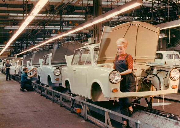 The Trabant car. East German VEB Sachsenring Automobilwerk. Trabant began manufacturing 1957 and production lasted until 1991. A total of 3 051385 Trabants were made. Trabant was developed as East Germanys answer to Volkswagen and the vision of a car for the people. It was called Trabbi or Trabi and became the most common car in East Germany. Trabant came to be somewhat of a symbol for East Germany during the time of the fall of the Berlin wall. Picture taken in Trabant carfactory in Sachsen in the 1960s. The young woman standing at the assembly line has the typical hairdo of the 1960s, the Beehive. A popular hairdo of the time where the goal was to create volume and height leaving the neck bare and elegant. Copyright: xClassicxPicturexLibraryx