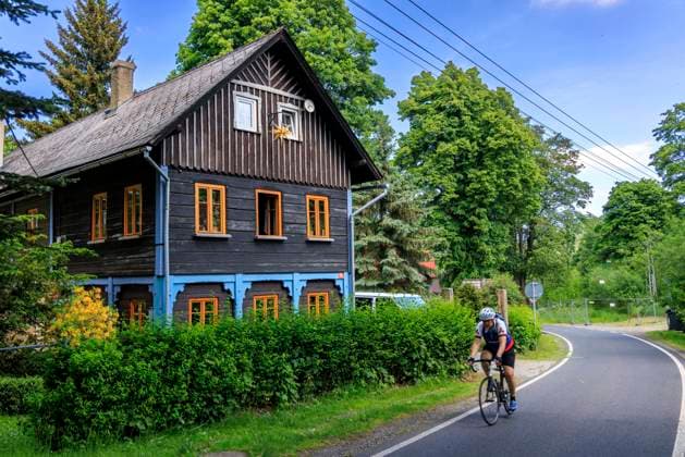 Umgebindehäuser in Krompach CZE Böhmen Krompach Copyright Â Krompach im Zittauer Gebirgeliegt (deutsch Krombach) ist eine Gemeinde des Okres Äaeska Lipa in der Region Liberec im Norden der Tschechischen Republik. In der Oberlausitz und im Zittauer Gebirge - stehen noch rund 6500 der größtenteils denkmalgeschützte Umgebindehäuser. Sie sind eine Mischung aus slawischer Blockstube und fränkisch-thüringischem Fachwerkbau. Das besondere daran ist, dass ein Teil des Hauses, nämlich die Blockstube, völlig separat steht. Das -Umgebinde - trägt das in Fachwerkbauweise gebaute Obergeschoss. In der Blütezeit der Hausweberei wurden dadurch die Erschütterungen der Webstühle nicht auf das übrige Gebäude übertragen. Nach Untersuchu