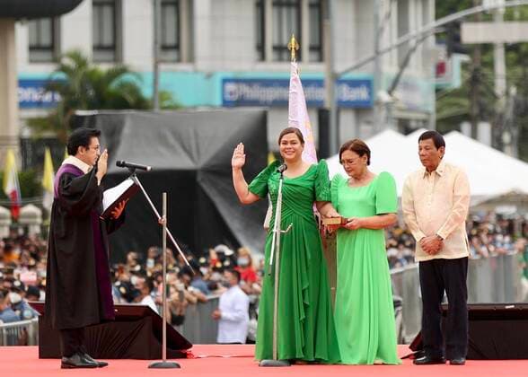 News Bilder des Tages (220619) -- DAVAO CITY, June 19, 2022 -- Sara Duterte-Carpio (2nd L) takes her oath of office as the 15th vice president of the Philippines as her father President Rodrigo Duterte (1st R) and her mother Elizabeth standing next to her in Davao City in the southern Philippines, June 19, 2022. A lawyer and former mayor of Davao City, Duterte-Carpio will officially assume office on June 30. Her six-year term ends on June 30, 2028. Duterte-Carpio won by garnering 32.2 million votes, the highest number of votes from all national candidates, in the May 2022 elections and about twice the 16.6 million votes cast for her father in the 2016 presidential race. Duterte-Carpio will also head the Department of Education in the incoming Marcos adm 