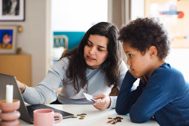 Mother teaching online payment to son on laptop at home Sweden, Stockholm, model released, property released Copyright: xMaskotx , MA93691