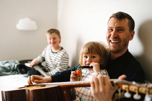 Portrait of happy father with guitar and daughter sitting in bedroom Sweden, Gothenburg, model released, property released Copyright: xMaskotx , MA93753
