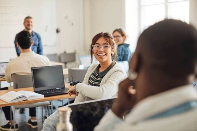 Smiling female student talking to male friend during lecture in classroom Sweden, Stockholm, model released, property released Copyright: xMaskotx , MA94056