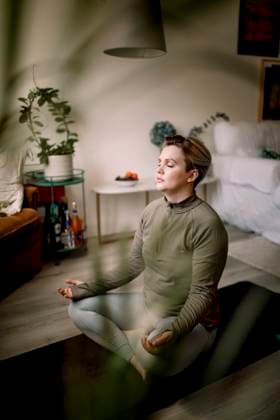 IMAGO Creative, Lifestyle, Tik Tok-Trend thatgirl Lesbian woman with eyes closed practicing yoga at home Sweden, Stockholm, model released, property released Copyright: xMaskotx , MA94151