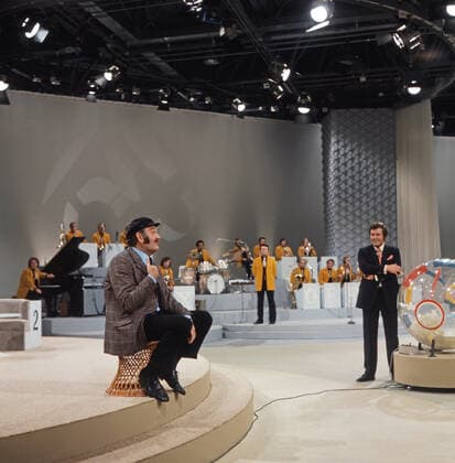 DREI MAL NEUN Drei mal Neun, ZDF Quizshow, Deutschland, 1971, im Bild: Showgast Jürgen von Manger, im Hintergrund Max Greger mit Bigband und Showmaster Wim Thoelke. Drei mal Neun, TV quiz show, Germany, 1971, on the photo: show guest, German comedian and cabaret artist Juergen von Manger, background: Max Greger with Big band and presenter Wim Thoelke., Deutschland Copyright: ArthurxGrimm UnitedArchives82007889 EDITORIAL USE ONLY