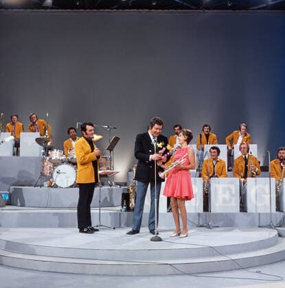 DREI MAL NEUN Drei mal Neun, ZDF Quizshow, Deutschland, 1971, im Bild: Max Greger mit Bigband, Showmaster Wim Thoelke und Trompetensolistin Carole Dawn Reinhart. Drei mal Neun, TV quiz show, Germany, 1971, on the photo: Max Greger and his Big band, presenter Wim Thoelke and the American trumpet soloist Carole Dawn Reinhart, Deutschland Copyright: ArthurxGrimm UnitedArchives82007901 EDITORIAL USE ONLY