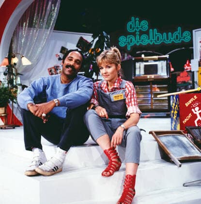 DIE SPIELBUDE Die Spielbude, ARD Spielshow, Deutschland, 1984, mit Ron Williams, amerikanischer Sänger und Gina Stephan als Moderatorin und Spielleiterin. Spielbude, ARD entertainment, 1984, with Ron Williams, American singer and presenter Gina Stephan as game leader., Deutschland Copyright: kpa UnitedArchives55042140 EDITORIAL USE ONLY