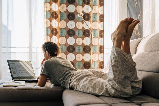 IMAGO Creative: Business - Work-Life Balance A short-haired woman lies at home on the couch and works on a laptop Vilnius, Vilnius County, Lithuania CR_EDSAHG220525-986846-01 ,model released, Symbolfoto