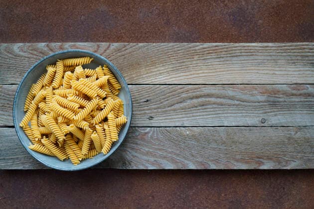 IMAGO Nature: Unsere Erde, Klimawandel, Ernährung, Pflanzen der Zukunft, Kichererbse Fusilli wholemeal pasta made with Tuscan chickpea flour and brown rice, on a wooden and metal background with space for text, Italy, Europe REDA&CO 1028_29_EBU26779