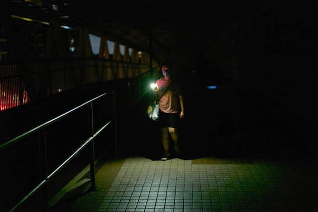 June 21, 2022, Hong Kong, China: A man crosses a bridge in the darkness lights up with his smartphone lamp in Tin Shui Wai. 140,000 Hong Kong households face a blackout after an electricity cable fire. Hong Kong China - ZUMAs197 20220621_zaa_s197_432 Copyright: xEmmanuelxSernax