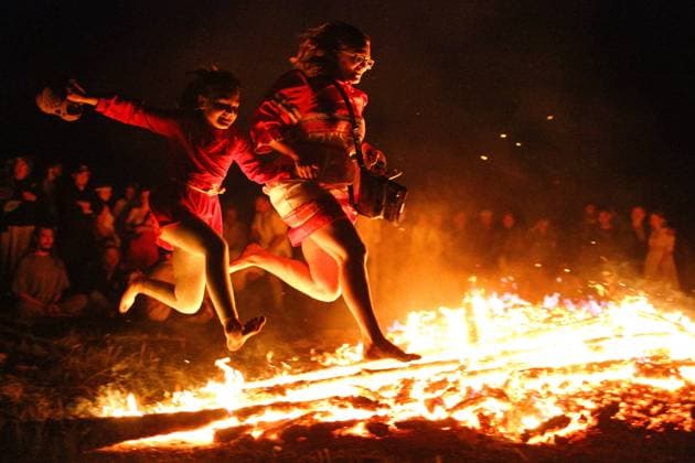 OMSK REGION, RUSSIA â€“ JUNE 21, 2022: People leap over flames at the Solntsestoyaniye Solstice Festival in the village of Okunevo. The festival s programme includes masterclasses in arts and crafts, lectures, a crafts fair, live music performances, performances by dance and music collectives, games, dances, etc. Yevgeny Sofiychuk TASS  TS1373EB