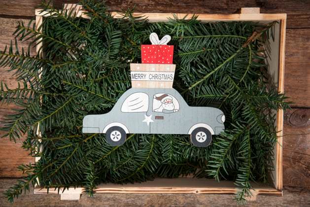 Crate filled with conifer twigs and Christmas decoration of Santa Claus delivering gifts by car, LBF03635