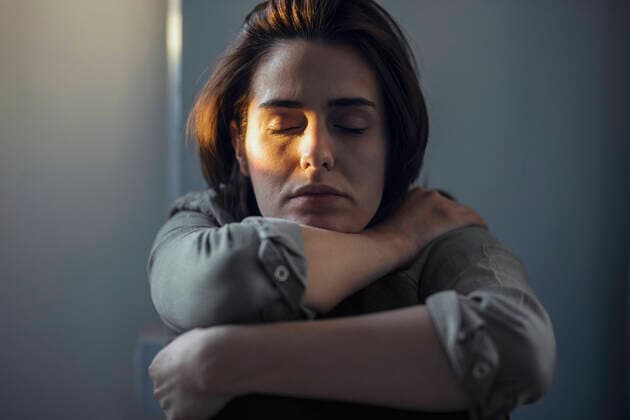 Creative Highlights Symbolbilder Woman with eyes closed sitting in dark at home model released, Symbolfoto property released, JSRF02004