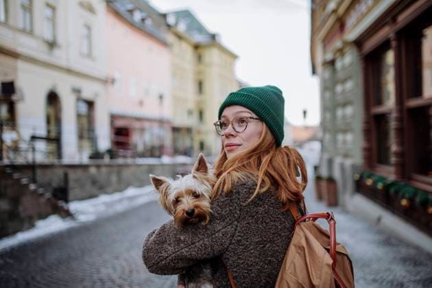 IMAGO Creative, Jahreszeit Winter in der Stadt IMAGO Creative: Winter in der Stadt Woman wearing backpack carrying pet dog in city model released, Symbolfoto property released, HAPF03191