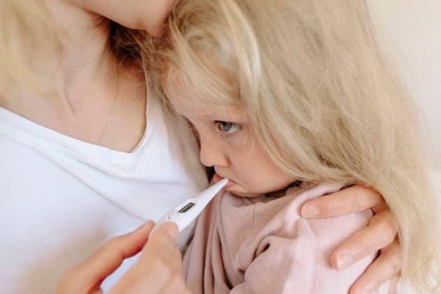 Mother carrying daughter and measuring temperature with thermometer at home model released, Symbolfoto, SIF00153